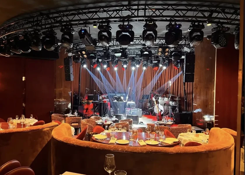 Dairesel truss üzerinde ışık armatürleri, sahne ve masalar — nuit blanche